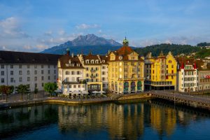 The colorful buildings near a river surrounded by mountains in Lucerne in Switzerland